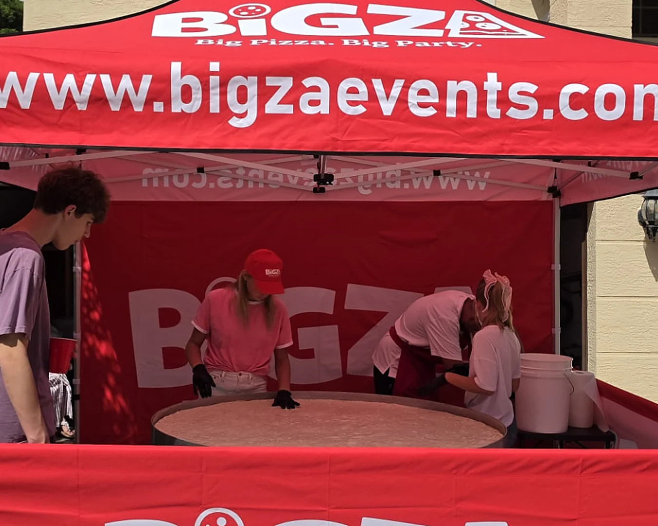 How big is Bigza? Size comparisons showing the 5-foot pizza next to a banana, an adult, a car and more — 4 of 4